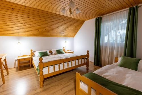 a bedroom with two beds and a wooden ceiling at Apartmaji Taler in Bohinj