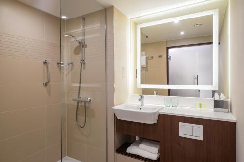 a bathroom with a sink and a shower with a mirror at Courtyard by Marriott Inverness Airport in Inverness