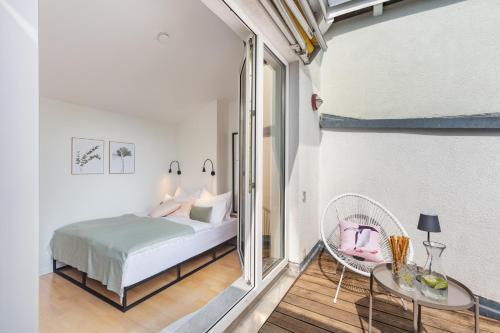 1 dormitorio con cama, ventana y mesa en Blueberry Living - Design Loft nahe München - Dachterrasse - S-Bahn, en Gauting