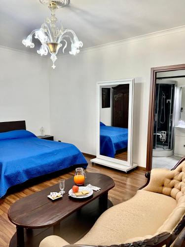 a bedroom with a blue bed and a table and chairs at Lo Scrigno B&B in Montemiletto