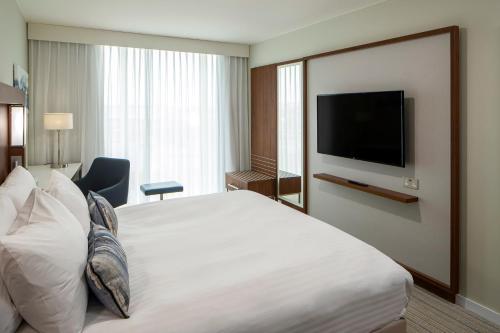 a hotel room with a bed and a flat screen tv at Courtyard by Marriott Inverness Airport in Inverness