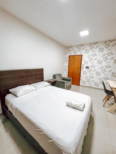 a bedroom with a large bed and a table and chairs at Departamento bonito y acogedor cerca de todo! in Asuncion