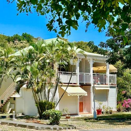a white house with palm trees in front of it at VILLA Ti Paradis ANSE DES ROCHERS in Saint-François