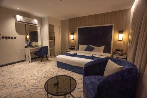 skyline Hotel & Suites في تبوك: غرفه فندقيه بسرير واريكه
