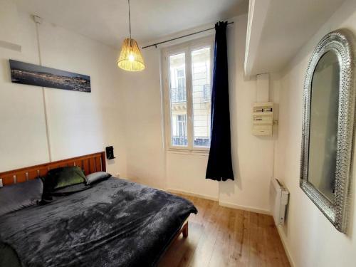 - une chambre avec un lit et une grande fenêtre dans l'établissement Grand appartement proche gare de Marseille hypercentre, à Marseille