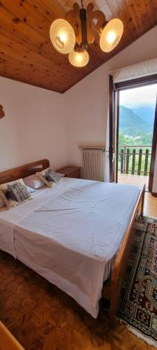 a bedroom with a large bed and a large window at Corte Toffoletti in Tarcento