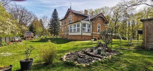 a large house with a yard with trees and grass at FamilyandBike in Neupetershain