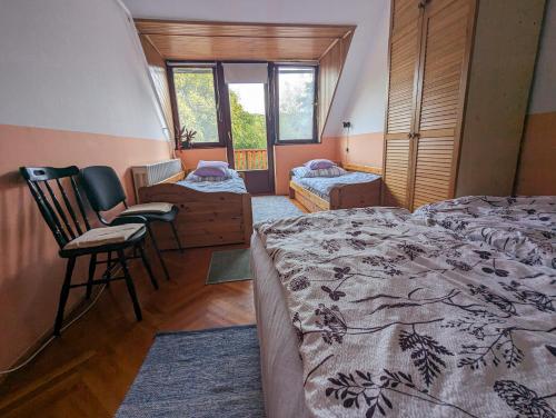 a bedroom with two beds and two chairs in it at Várkapitány-lak in Csesznek