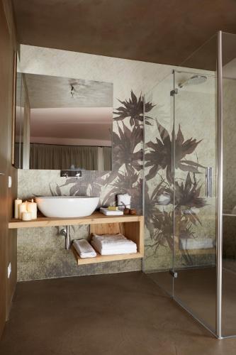 a bathroom with a sink and a glass shower at Boutique Hotel Oche Selvatiche in Grado
