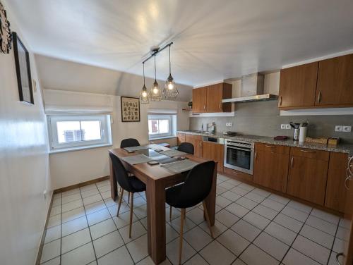 uma cozinha com uma mesa de madeira e cadeiras em 3 Bedroom apartment in the Center of Larochette em Larochette