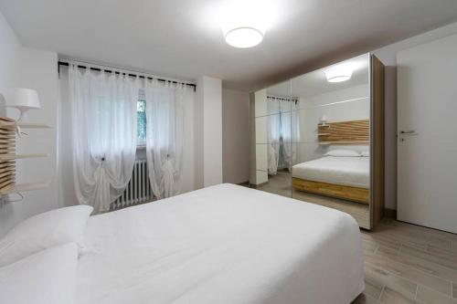 a white bedroom with a large bed and a mirror at Villa de Riseis B&B in Pescara