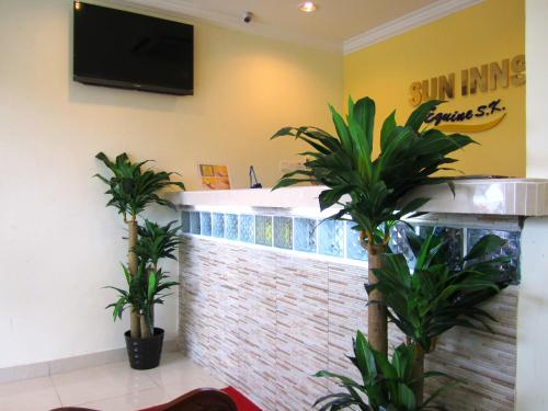 a restaurant with two palm trees in a lobby at Sun Inns Hotel Equine, Seri Kembangan in Seri Kembangan