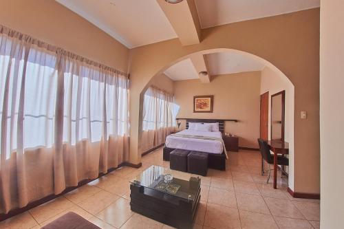 a hotel room with a bed and a table at Hotel America Pucallpa in Pucallpa