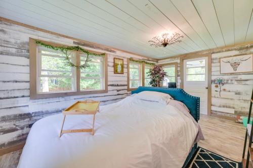 a bedroom with a blue bed in a room with wooden walls at Lakefront Michigan Abode with Deck and Fire Pit! in Cheboygan