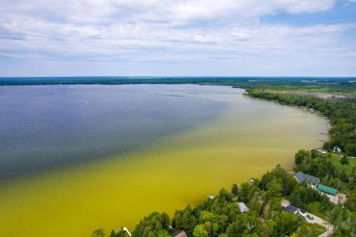 an aerial view of a large body of water with yellow algae at Lakefront Michigan Abode with Deck and Fire Pit! in Cheboygan