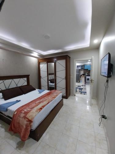 1 dormitorio con 1 cama y TV de pantalla plana en Hayat Pyramids House 237T, en ‘Ezbet `Abd el-Ḥamîd
