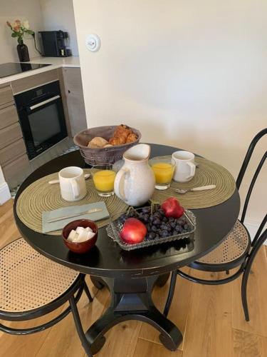 - une table noire avec un bol de fruits dans l'établissement Appartement très confortable le Renaissance entre Paris et CDG, à Écouen