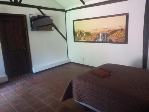 Quinta los Eucaliptos في كيتو: غرفة نوم بسرير ودهان على الحائط