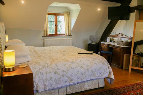 a bedroom with a bed and a desk and a window at Huntlands Farm Bed & Breakfast in Bromyard