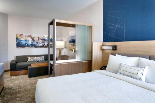 ein Hotelzimmer mit einem Bett und einem Wohnzimmer in der Unterkunft SpringHill Suites By Marriott Salt Lake City West Valley in West Valley City