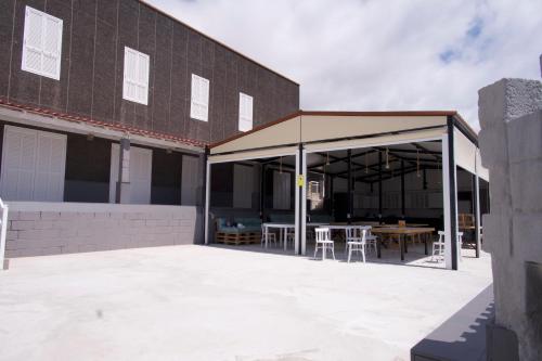 a pavilion with tables and chairs outside of a building at Las Eras Nest Hostel in Las Eras