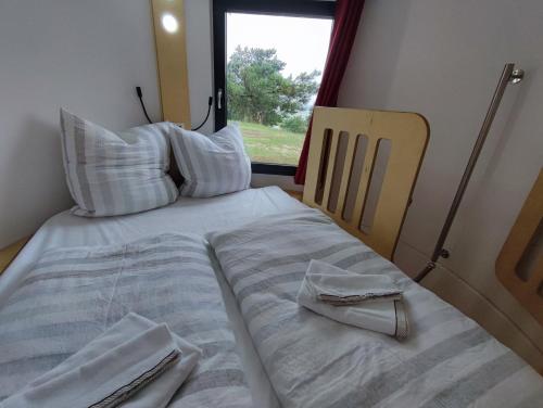 a bed with two towels on it in a room with a window at Tiny House Ückeritz in Ueckeritz