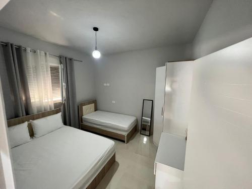a small bedroom with two beds and a window at Twins Apartment in Përmet