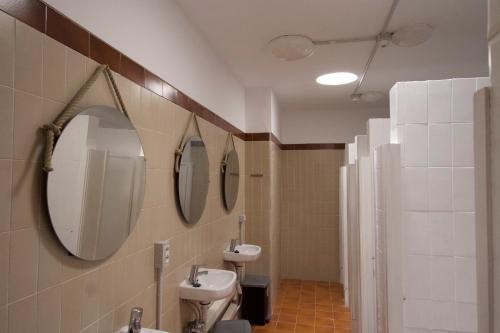 a bathroom with two sinks and two mirrors on the wall at Las Eras Nest Hostel in Las Eras