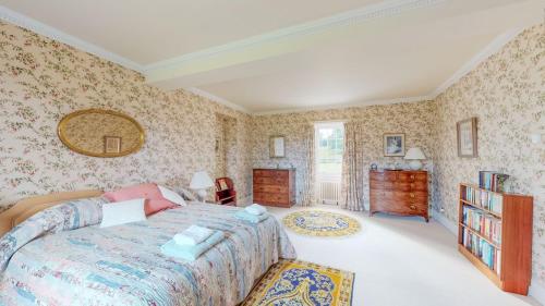 a bedroom with a bed and floral wallpaper at Airds of Kells House in Castle Douglas