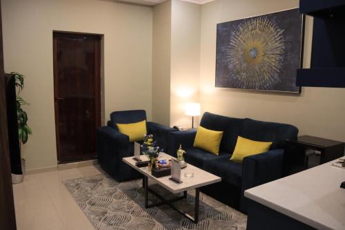 a living room with a blue couch and yellow pillows at شقق سوات للشقق المخدومة 4 in Al Khobar