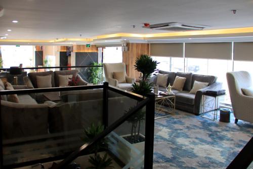 een lobby met banken en stoelen in een gebouw bij Swat Hotel Apartments 4 in Al Khobar