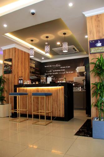 a bar in a restaurant with two stools at شقق سوات للشقق المخدومة 4 in Al Khobar