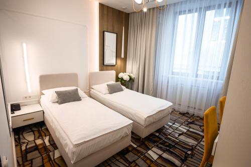 a hotel room with two beds and a window at Hotel Kazimierz in Kraków