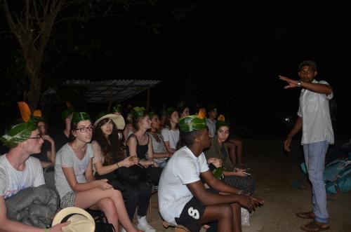 a group of people wearing green bandanas watching a speaker at Spiritual Nature Farm - Sri Lanka in Matale