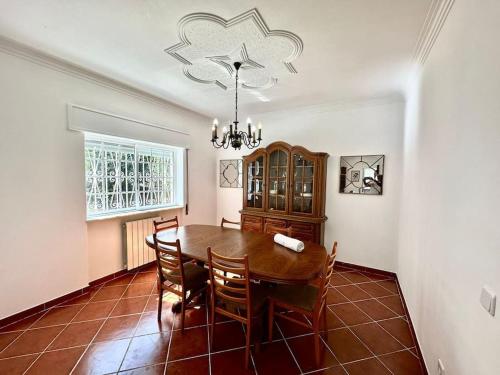 jadalnia ze stołem, krzesłami i żyrandolem w obiekcie Ferraguda Garden House w mieście Carregado