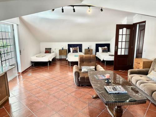 ein Wohnzimmer mit einem Sofa und einem Tisch in der Unterkunft Ferraguda Garden House in Carregado