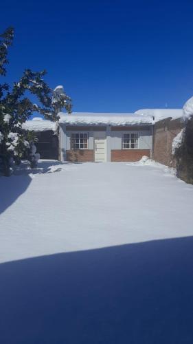 a snow covered driveway in front of a house at Casa moderna en zona tranquila in Malargüe