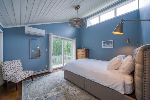 a blue bedroom with a bed and a chair at The Mountain House Windham Retreat with Hot Tub! in Windham