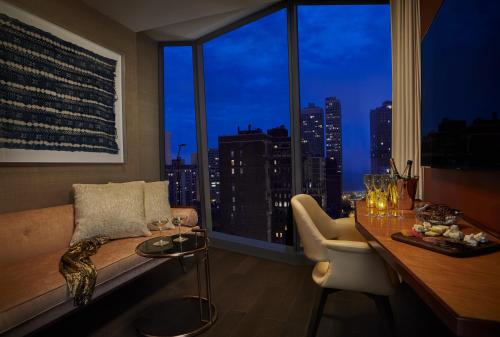 a living room with a couch and a large window at Viceroy Chicago in Chicago