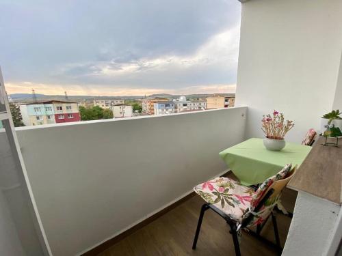 a balcony with a table and a chair and a view at Alin's home in Ocna-Mureşului