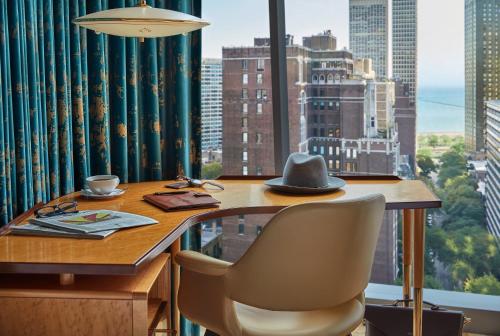 a table with a hat and chairs in front of a window at Viceroy Chicago in Chicago