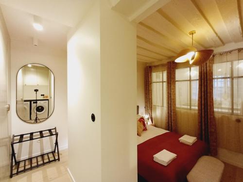 a bedroom with a bed with a red blanket and a mirror at Happy Stay Paris - Suite Hotel de Ville le Marais in Paris