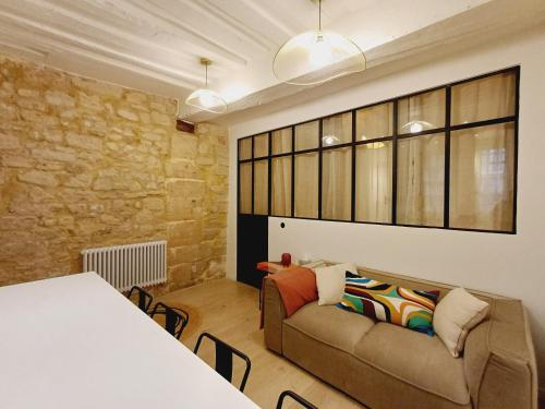 a living room with a couch and a table at Happy Stay Paris - Suite Hotel de Ville le Marais in Paris