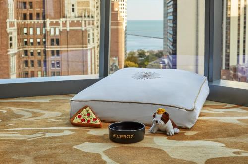 a bedroom with a bed and a bowl of pizza at Viceroy Chicago in Chicago