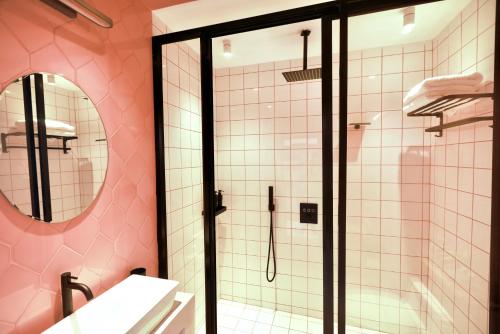 uma casa de banho com um chuveiro e um espelho. em Adika - The beachfront Loft em Chaloklum