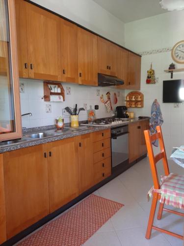 a kitchen with wooden cabinets and a stove top oven at Gufo Azzurro in Sulmona