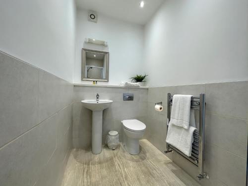 a bathroom with a sink and a toilet at Station Lounge & Rooms in Clitheroe