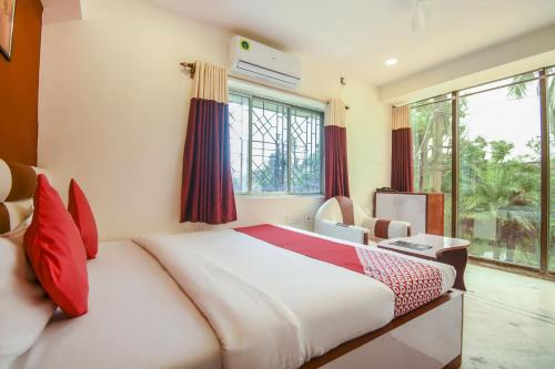 1 dormitorio con cama y ventana grande en Super OYO Flagship Red Stone Near Netaji Subhash Chandra Bose International Airport en Calcuta