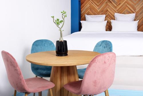 a table with pink chairs and a bed at Adika - The beachfront Loft in Chaloklum
