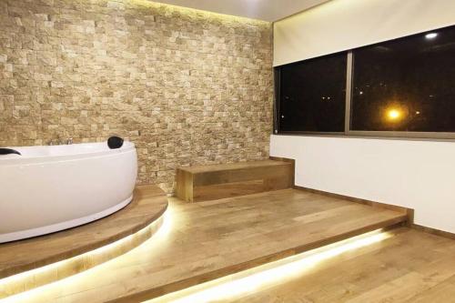 een badkamer met een bad en een groot raam bij Bonita casa en sector residencial al norte de Loja in Loja